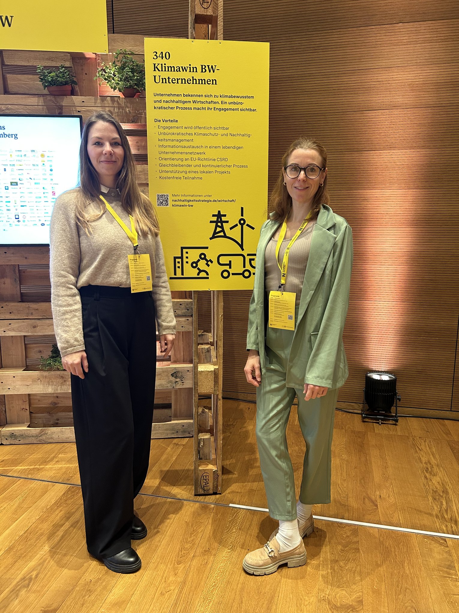 Mitglieder unseres Nachhaltigkeitsteams beim Klima.Länd-Kongress in Heilbronn. Zwei Frauen stehen vor dem Veranstaltungsschild Klima.Länd.